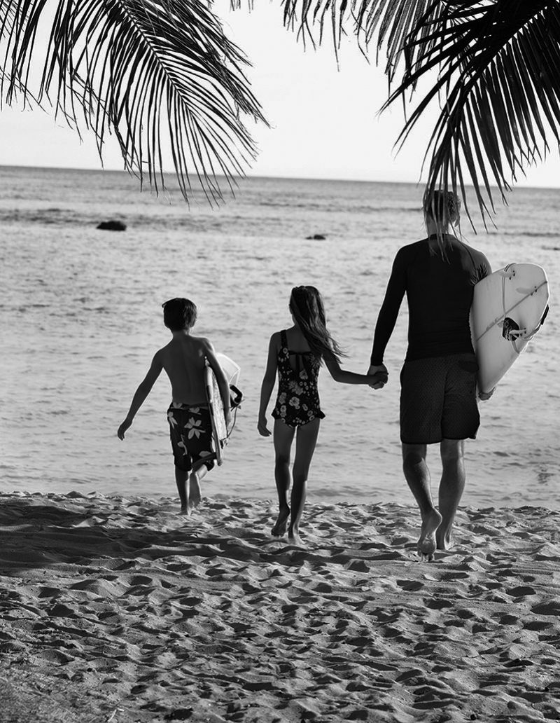 男人带着孩子在沙滩上散步