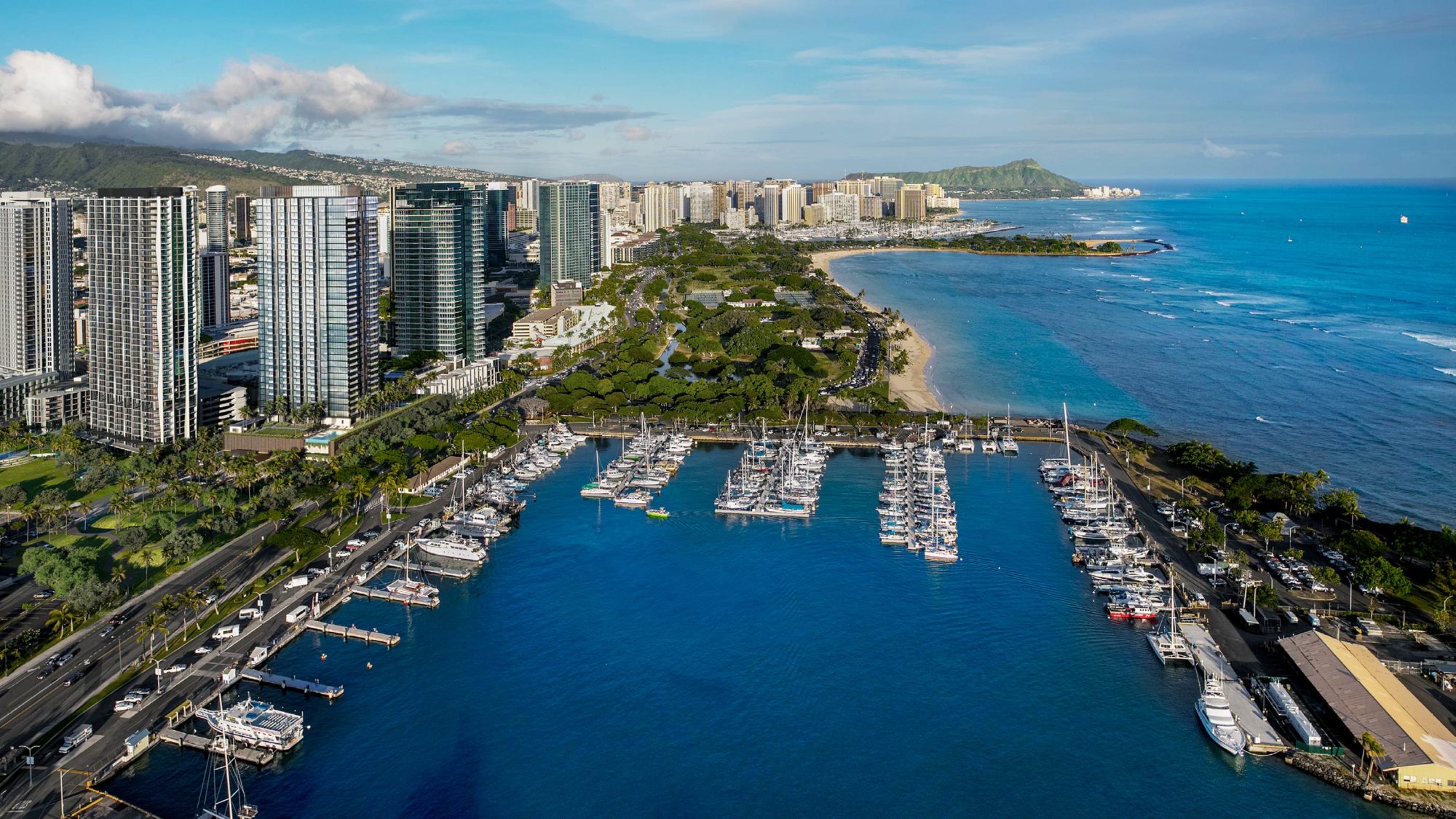 Aerial image of Victoria Place tower overlooking Kewalo Harbor, Ala Moana Beach Park, and Magic Island, with Waikiki and Diamond Head in the distance.