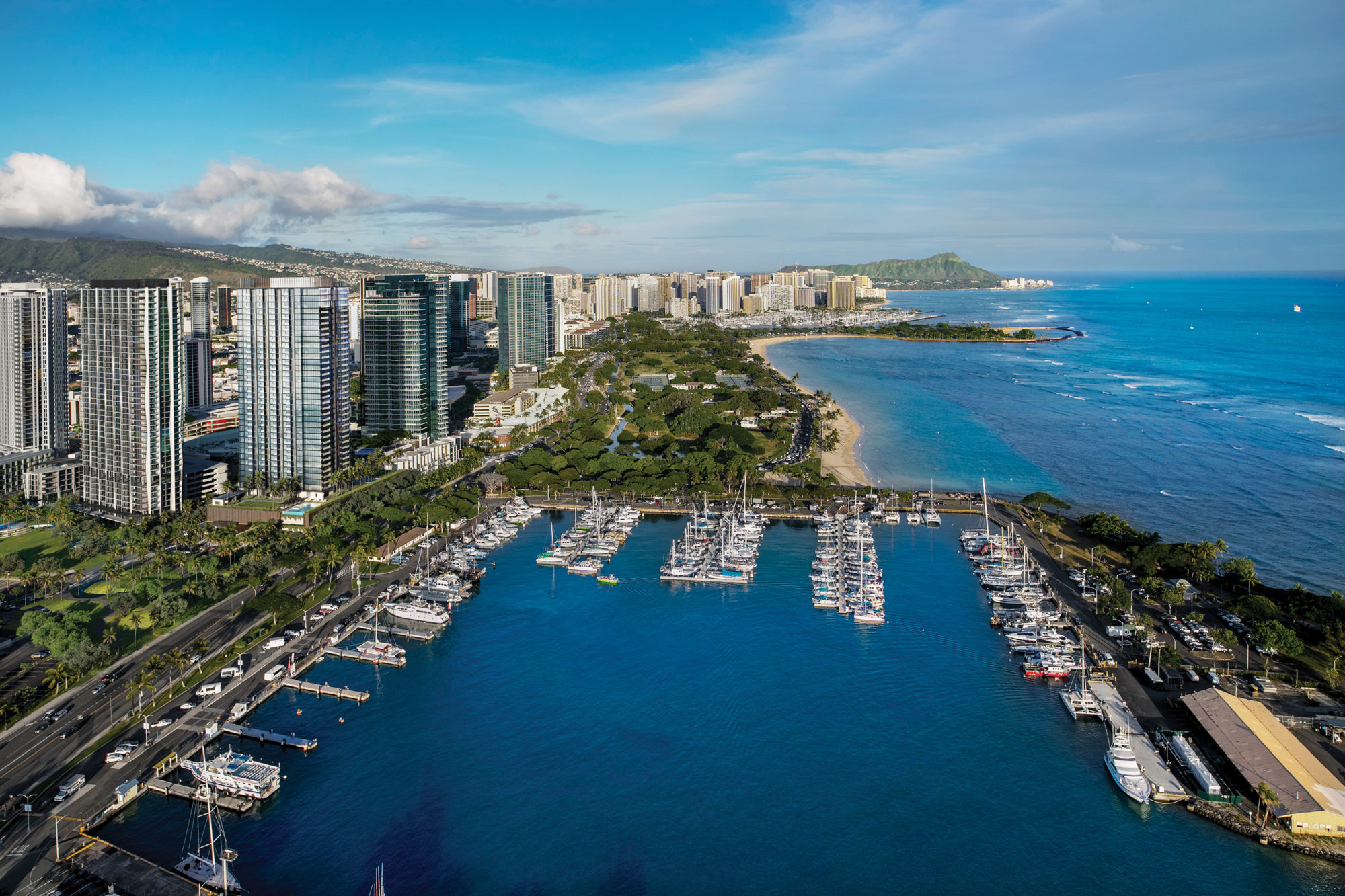 Aerial image of Victoria Place tower overlooking Kewalo Harbor, Ala Moana Beach Park, and Magic Island, with Waikiki and Diamond Head in the distance.